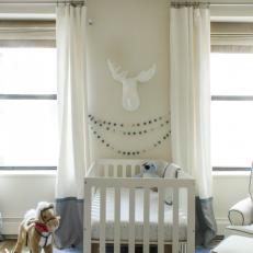 Pom Pom Garland and Faux Moose Head Above Crib in Nature Inspired Nursery