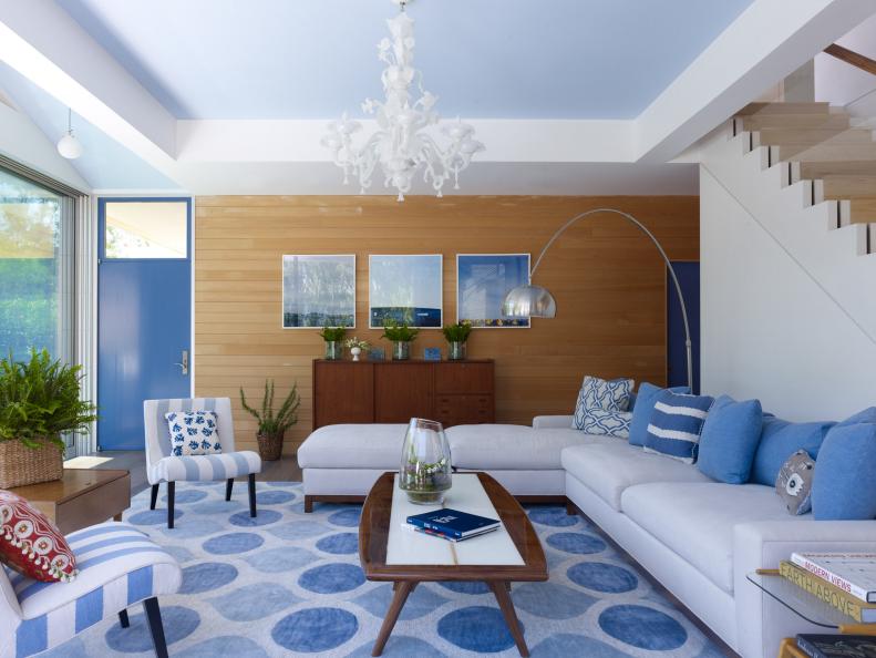 "As this is a summer house with close connections to the water -- bay and pool -- using blues as strong accent colors was only natural," says architect Stuart Disston, who designed the house (and is also the artist of the three blue photo collages on the wood-paneled wall). The rug takes its color cues from both the door and ceiling, which is painted the color of the palest blue sky.