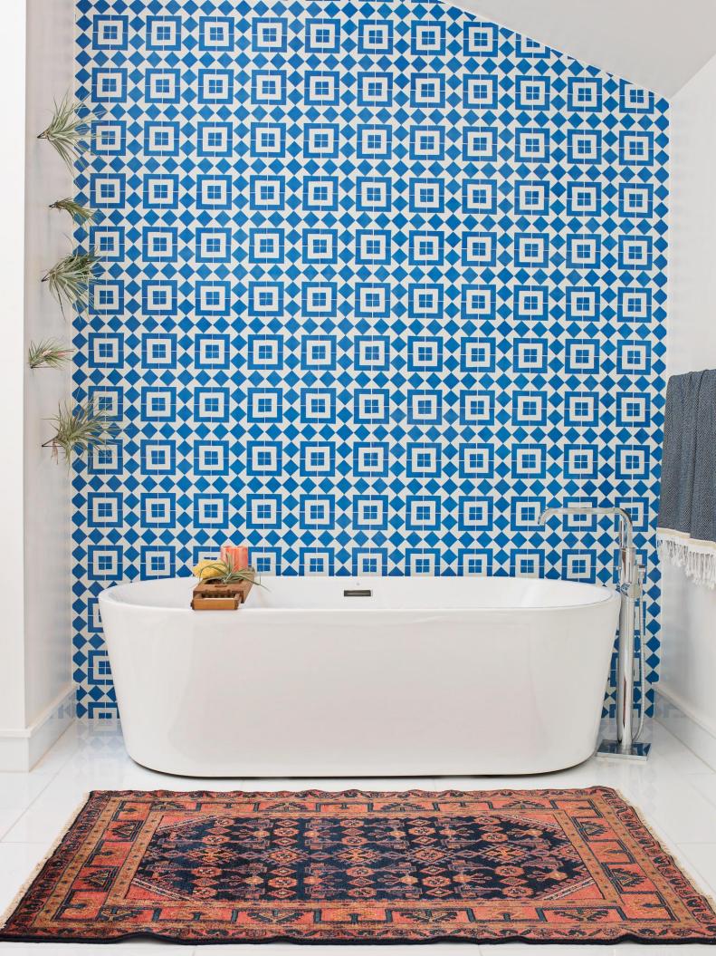 To update an overly chilly master bath, designer Regan Baker used cement tile—a trendy material that’s more often seen in black and white, and on the—to great effect, adding color and pattern, while preserving the home’s contemporary style. “This master bathroom was originally all white which made it feel pretty cold, impersonal, and sterile, but it was also very contemporary,” says Baker. “The clients are fun people, and the space didn't reflect their personalities well. In addition, the bathtub got lost against a white wall, so the blue cement tile was a great way to warm up the space, and add a fun color and pattern. This tile also creates a great focal point when you walk into the room. Choosing such a pop-y shade of blue keeps the room feeling modern and bright, while adding warmth to the space.”