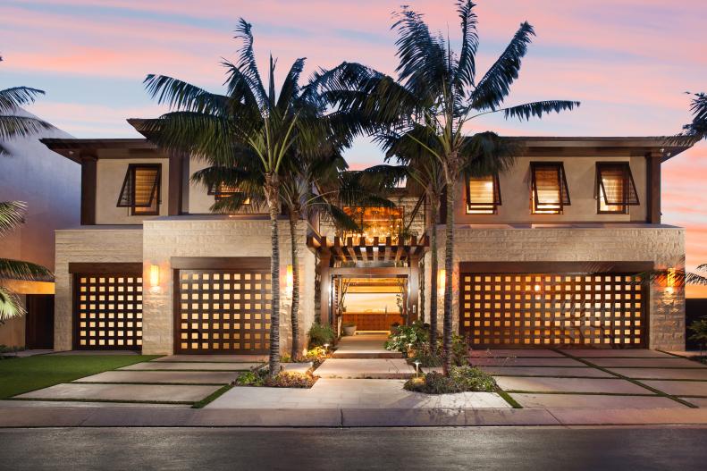 Front View at Dusk of Contemporary Beach House Lined With Palm Trees