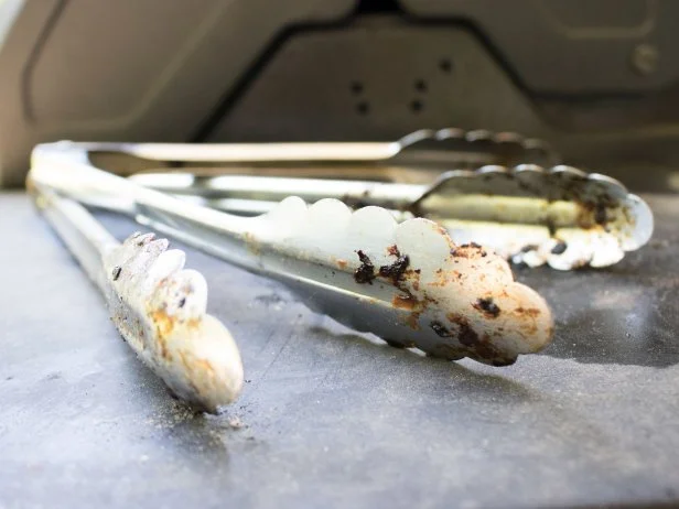 Cleaning dirty grilling utensils.