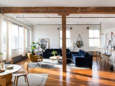 Modern, Open Floor Loft With Hardwood Floors, White Painted Brick Walls and Navy Sofas