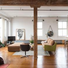 Open Floor Loft Living Room With Natural Wood Support Beams, Midcentury Modern Furniture and White Brick Walls 