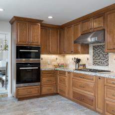 Kitchen With Dual Ovens and Ceiling-Height Wood Cabinets