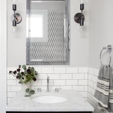 Bathroom With Marble-Top Black Vanity and Tile Backsplash