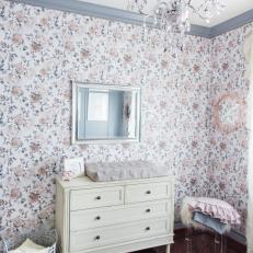 White Dresser in Floral-Wallpaper Nursery With Chandelier