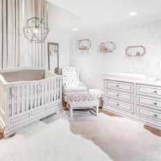 Boy's White Nursery With Animal Skin Rugs and Gold Accents