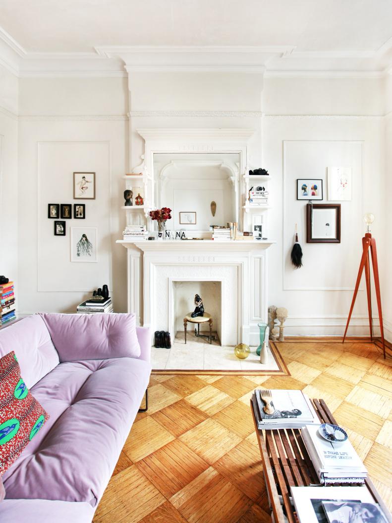 The living room epitomizes the style of this home. Strong architectural details are complemented, not covered, by tastefully understated gallery walls. And once again the white walls and wood floors are the perfect backdrop for the home’s boldest color statement—an inviting velvet sofa in a soft, pink blush. Though small accessories, sculptures and pieces of art accent the room throughout, the biggest pattern statement in the room is made by the wood floor, the repeating diamond geometric blends seamlessly into the room while creating visual interest from the floor up.