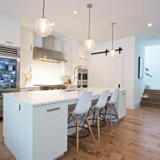 White Open Plan Kitchen With Glass Pendants