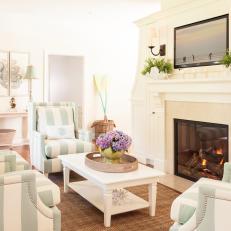 White Coastal Living Room With Fireplace and Striped Chairs