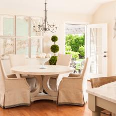 White Dining Area With Topiaries and Slipcovered Armchairs
