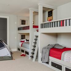 Built-In Bunk Beds With Red Linens and Central Ladder