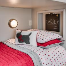 Single Bunk Bed With Red Comforter and Small Chalkboard