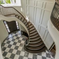 Entrance Foyer With Curved Staircase and Checkerboard Floor