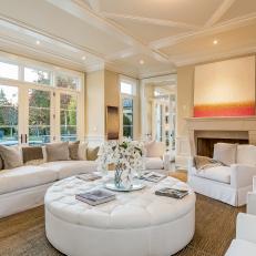 Neutral Living Room With Coffered Ceiling and Round Ottoman