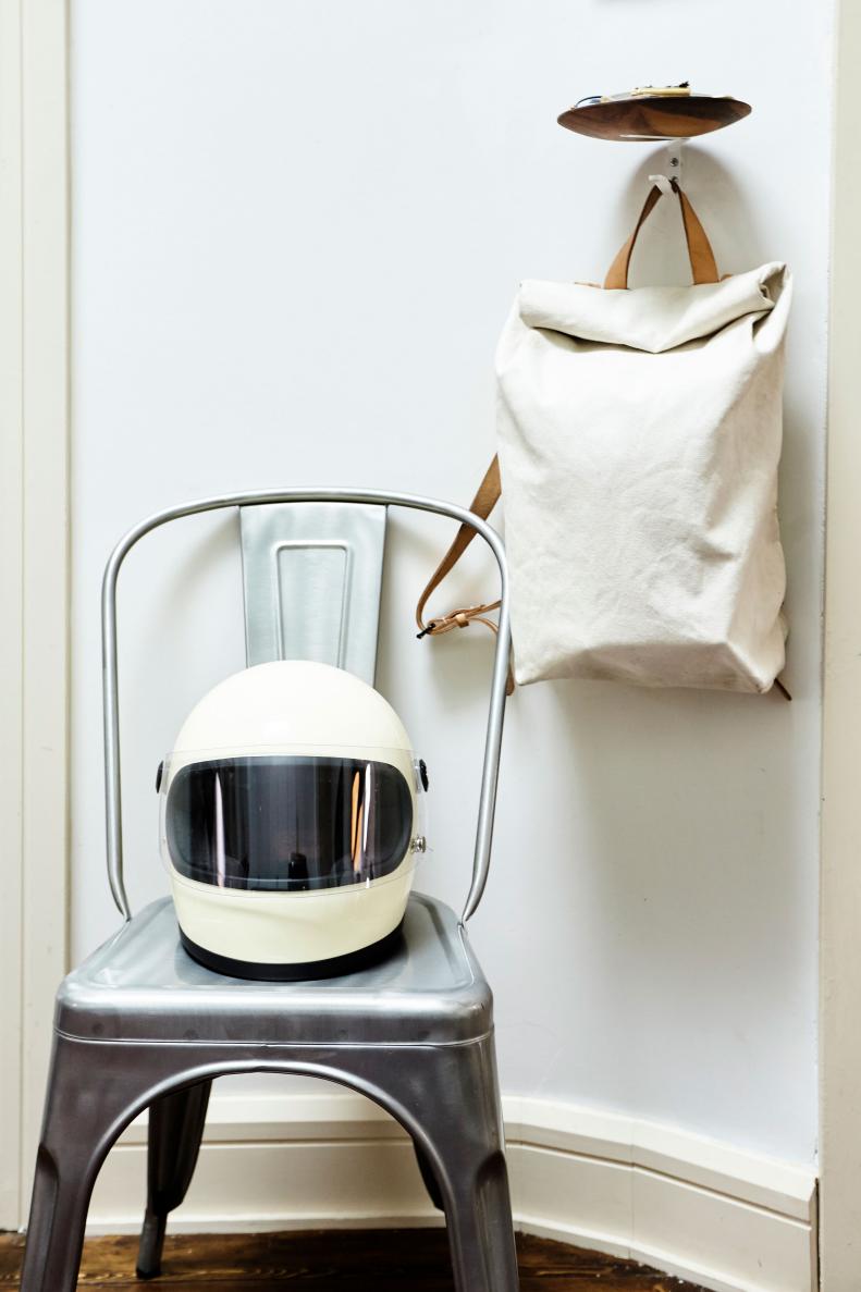 Tina and Jared have carved out a small entryway at the entrance to their home. A tray with a hook extension is a perfect catchall for keys, change and bags. And a chair by the door offers a place to store Jared’s motorcycle helmet. 