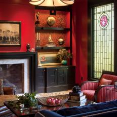Red Living Room With Navy Sofa and Wallpaper-Lined Built-Ins