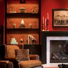 Red Living Room With Leather Chair & Wallpaper-Lined Shelves