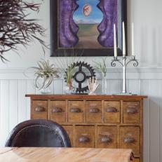 Dining Room With Vintage Apothecary Chest and Modern Artwork