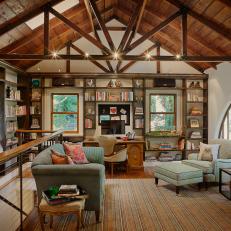Living Room With Bookshelves, Exposed Beams, & Arched Window
