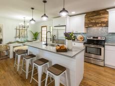The Brown's newly renovated kitchen features all new stainless steel appliances, cage pendant lights and a quartz counter top kitchen island, as seen on Listed Sisters. (After #13)