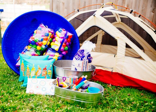 You will need: tent, tablescloth, buckets, sand, toys, plastic pool and toy balls.
