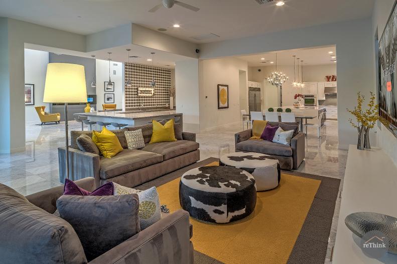 Sitting Area With Gray-and-Yellow Area Rug and Cowhide Ottomans