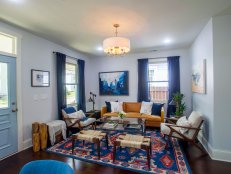 Blue Living Room with Brown Leather Sofa and White Chairs 