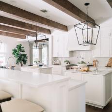 White Kitchen With Ceiling Beams, Two Islands and Eat-In Bar