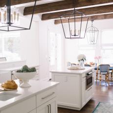 Two White Kitchen Islands Under Ceiling With Exposed Beams
