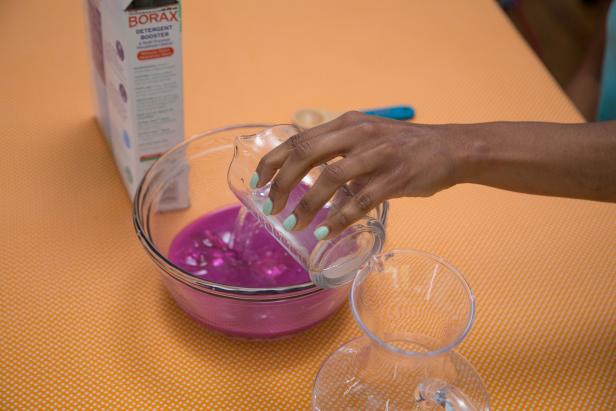 Pour the borax solution into the bowl of colored glue.