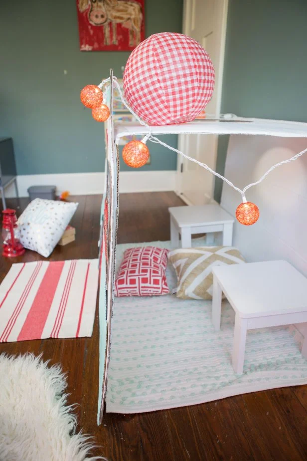 Use string lights, pillows, rugs and small furniture to make the inside of the play camper cozy.