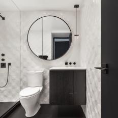 Black and White Master Bathroom With Round Mirror