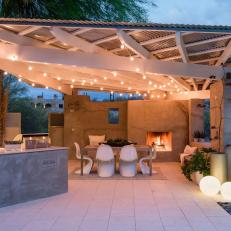 Bistro Lights, Fireplace Illuminate Outdoor Dining Space