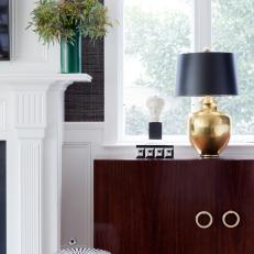 Wooden Cabinet and Striped Round Stool Near White Fireplace