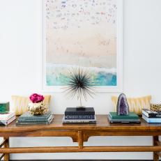 Wooden Console Table Beneath Painting With Coastal Colors
