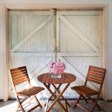 Folding Outdoor Wooden Table and Chair Near Old Garage Door