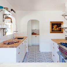 White Cottage Kitchen With Gas Range and Arched Door
