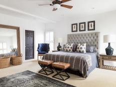 White Master Bedroom With Gray Headboard and Leather Stools