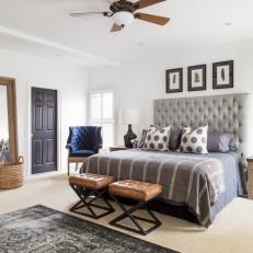 White Master Bedroom With Gray Headboard and Leather Stools