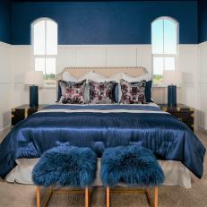 Rich Blue-and-White Master Bedroom With Furry Stools