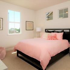 Pale Pink Guest Bedroom With Black Bed and Pink Pouf
