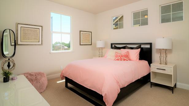 Pale Pink Guest Bedroom With Black Bed and Pink Pouf | HGTV