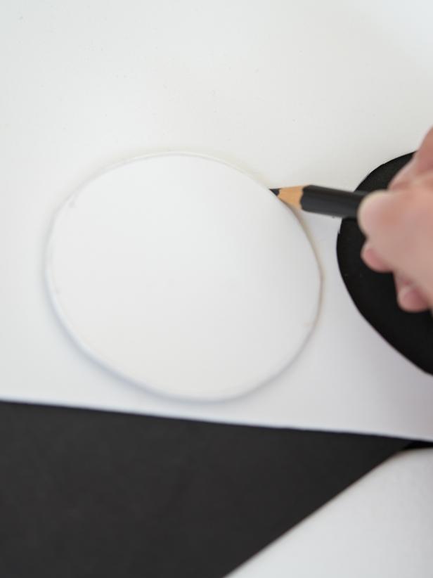On white craft foam, use pencil to draw out a circle, about 3â in diameter. Cut out with scissors. Use first circle as a template to trace second white circle. Cut out second circle. Repeat this process with black foam, making two circles about 1/2â in diameter. Tip: Trace a drinking glass to create two white circles.