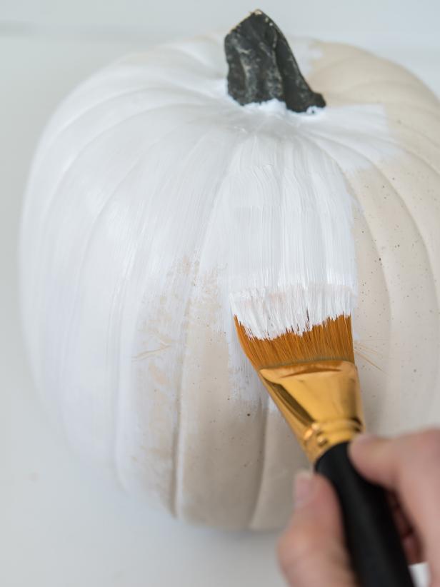 Using a 1 Â½â   flat paint brush, paint pumpkin with two coats of white acrylic paint.  Allow paint to dry properly between coats and before moving to step 2.  Tip: As an alternative, pumpkin can be painted with spray paint.