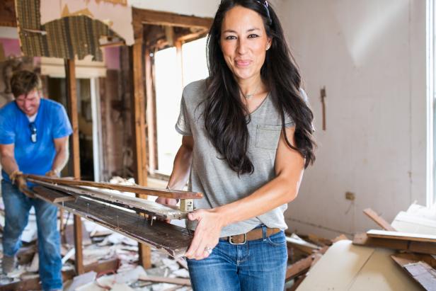 Hosts Chip and Joanna Gaines remove debris from the kitchen of the Bell home, as seen on Fixer Upper. (action)