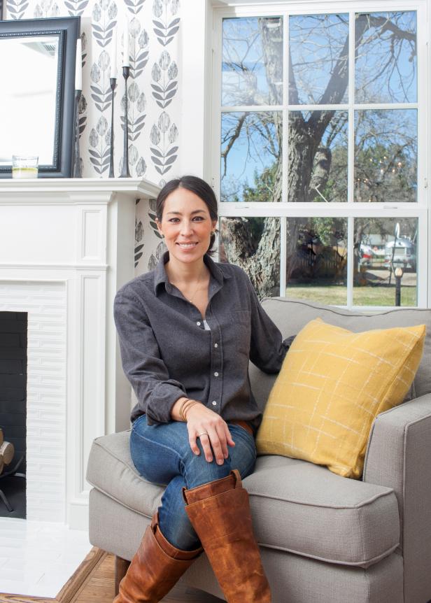 Joanna Gaines sits on a chair designed by Magnolia Home in the Masserall's newly remodeled living room, as seen on Fixer Upper. (After)