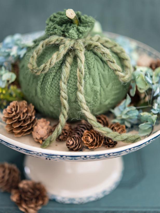 Cozy up a plain pumpkin with an old or thrifted sweater!  Itâ  ll bring amazing texture to any fall arrangement.
