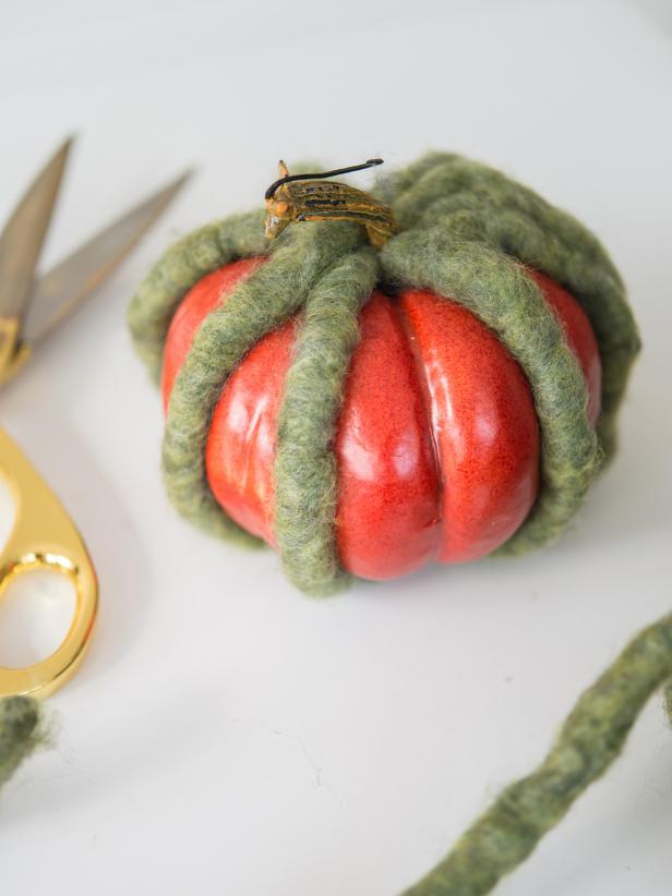 Yarn can also be affixed in the direction of the lines of the pumpkin.  For this design, cut and glue pieces of yarn along the natural recessed lines of the pumpkin.  Fill in with smaller pieces of yarn until pumpkin is covered.