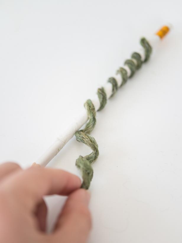 Once dry, gently unwind yarn from pencil.  Trim ends and cut into two pieces, one slightly longer than the other.  Affix with hot glue at the base of pumpkin stem.
